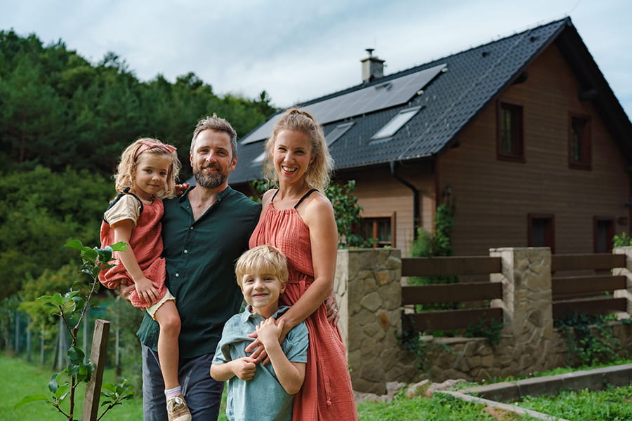 happy family near their house with solar panels